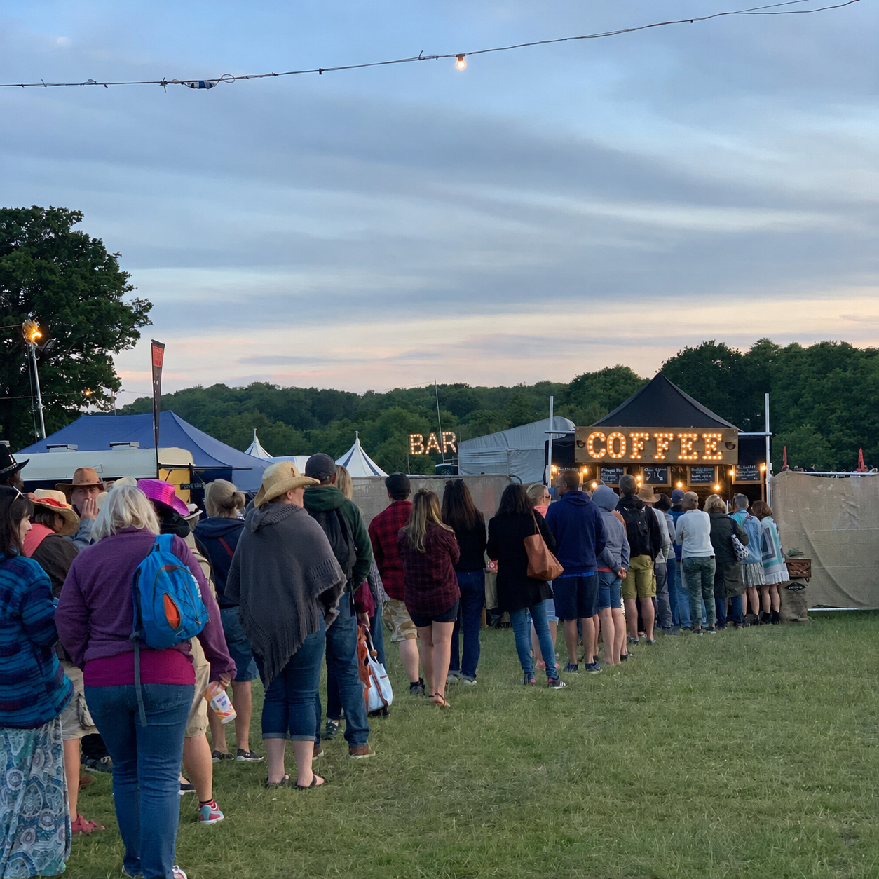 Queue of festival-goers at the Fine Grind COFFEE marquee at dusk under festoon lights