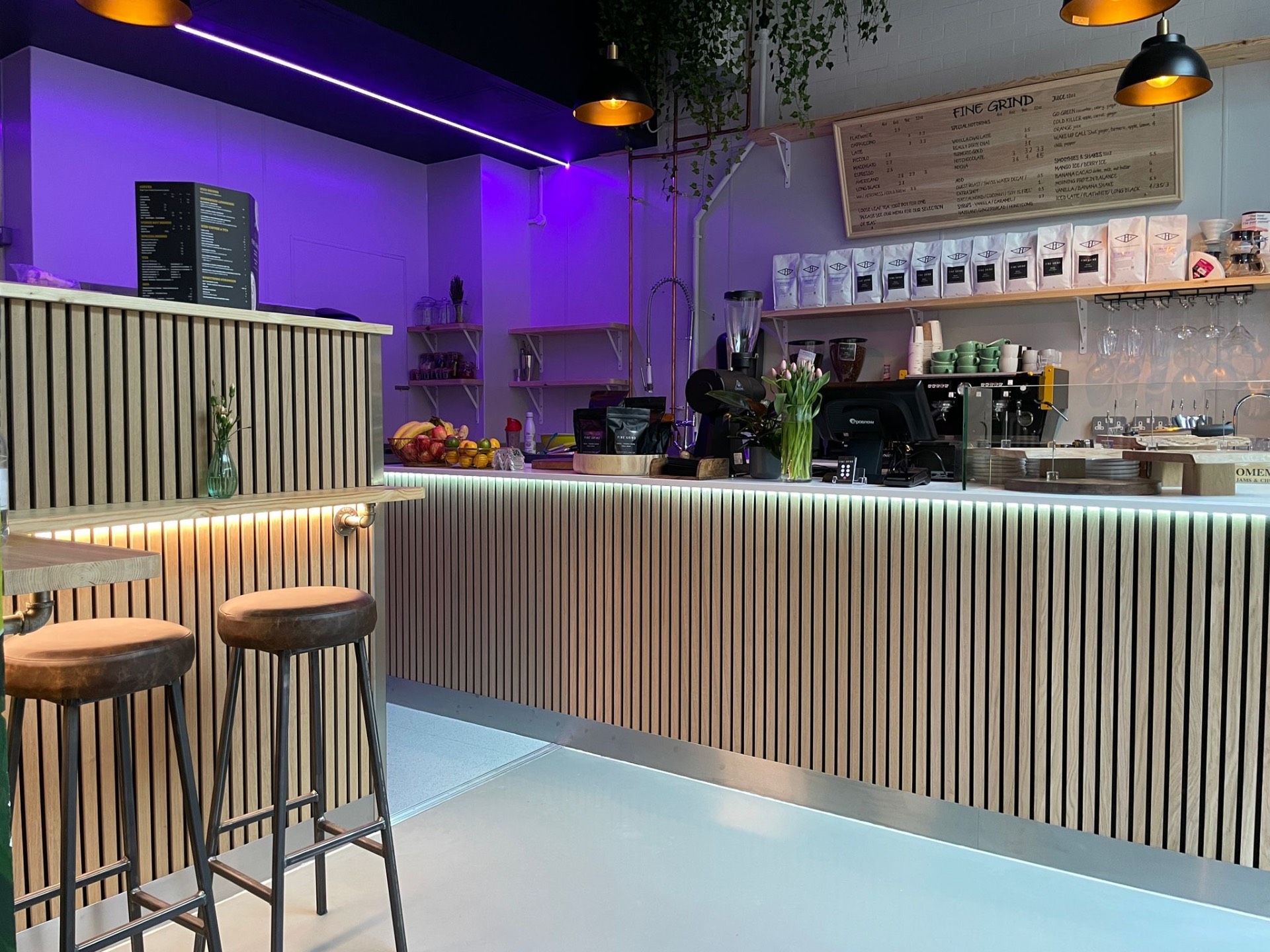 Interior of the Fine Grind café with ribbed timber counter and purple evening lighting